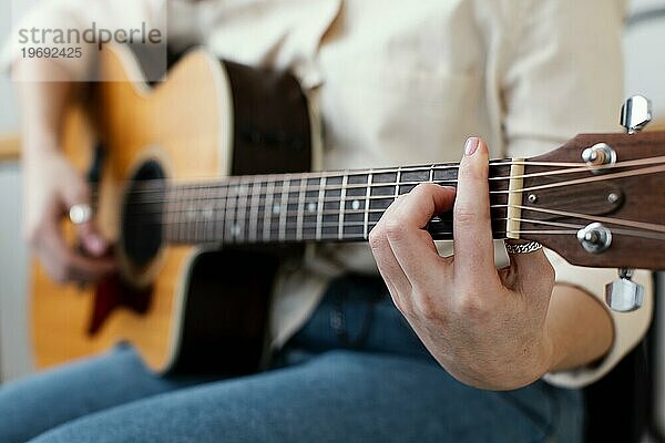 Seitenansicht Musikerin spielt akustische Gitarre