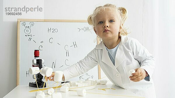 Niedliches Kleinkind  das mit dem Whiteboard Mikroskop etwas über Wissenschaft lernt