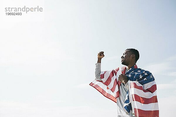 Afroamerikanischer Mann wickelt usa Flagge