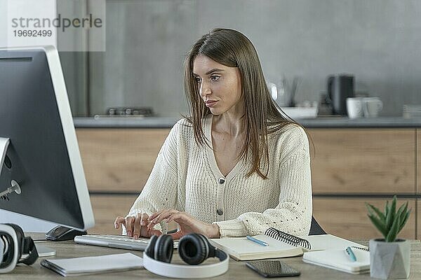 Frontansicht einer Frau bei der Arbeit im Medienbereich mit einem Personal Computer