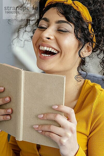 Portrait Frau lachend beim Lesen eines Buches