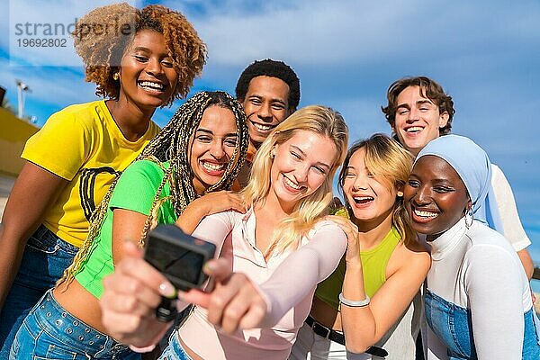 Frontalaufnahme eines multiethnischen Freundes  der ein Selfie mit einer Gopro Kamera macht