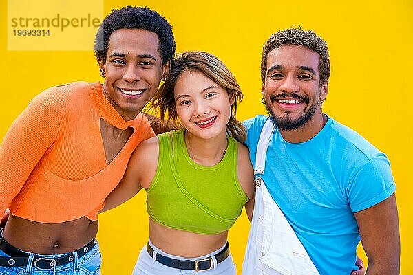 Geschlecht und ethnische Vielfalt Menschen posieren lächelnd in die Kamera in einem gelben Hintergrund