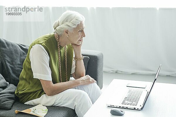 Ältere Frau sucht Laptop mit Konzentration