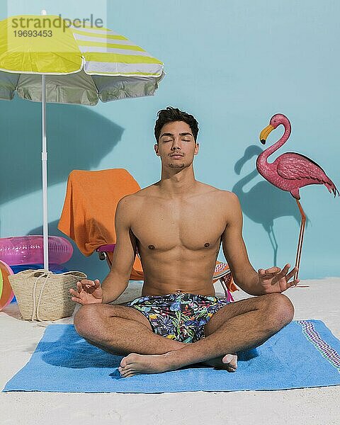 Junger Mann meditiert dekorativen Strand