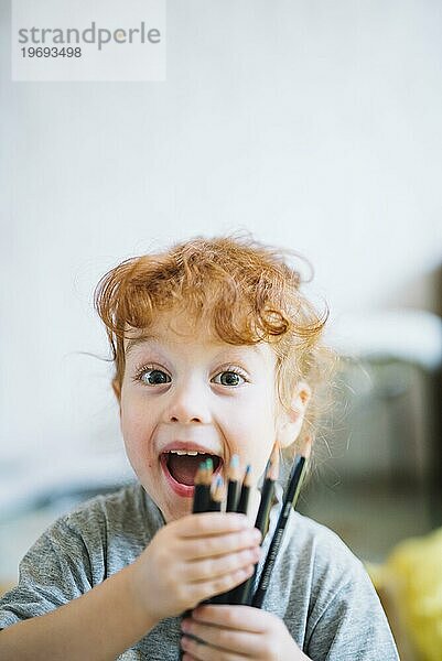 Glückliches Mädchen zeigt einen Haufen Bleistifte