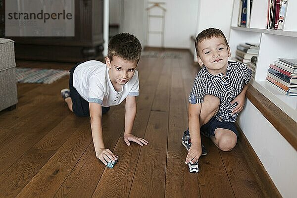 Zwei Jungen spielen mit Auto Spielzeug Hartholz Boden