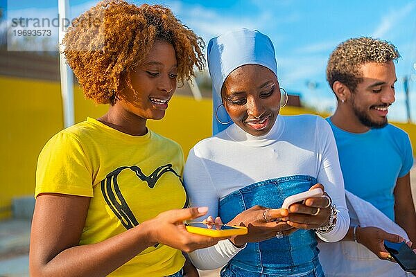 Seitenansicht von zwei schönen jungen Frauen aus Afrika  die auf der Straße telefonieren