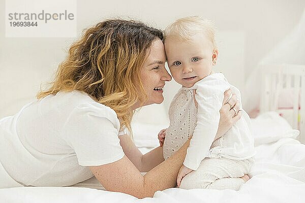 Niedliches kleines Mädchen spielt mit seiner Mutter zu Hause