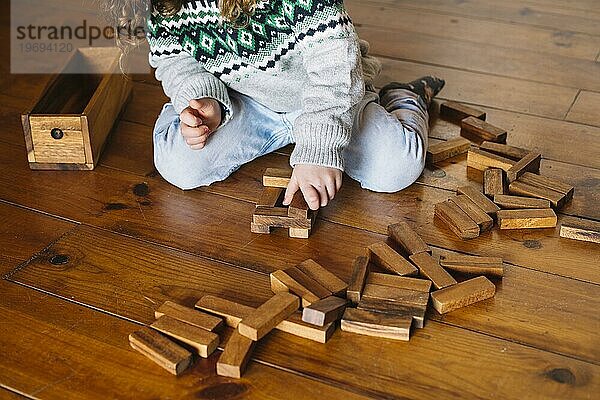 Mädchenhand spielt Holzklotzspiel zu Hause