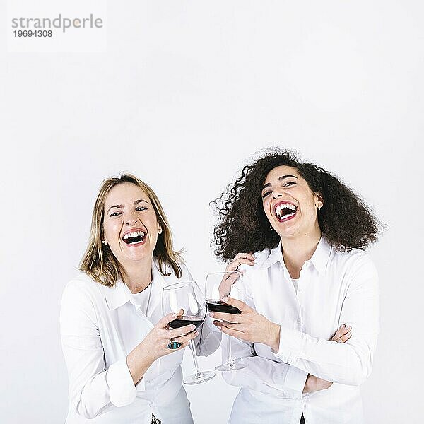 Lachende Frauen  die auf Gläser anstoßen