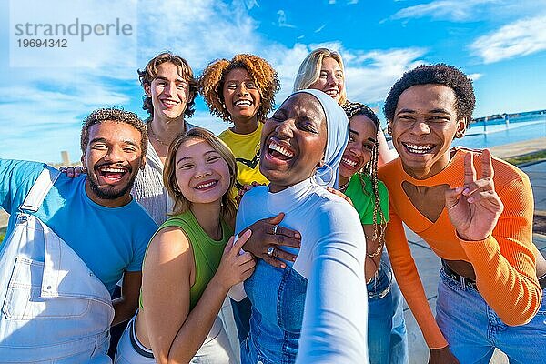 Junge multirassische Menschen lachen zusammen  während sie ein Selfie in der Stadt Straße