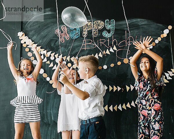 Fröhliche Kinder lassen Luftballons steigen Geburtstagsfeier