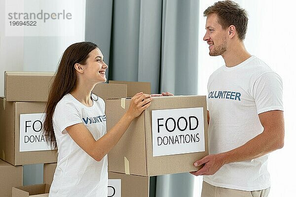 Freiwillige Helfer bei der Handhabung von Kisten mit Lebensmittelspenden