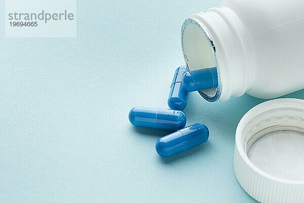 Hohe Ansicht blaue Pillen aus dem Behälter verschüttet