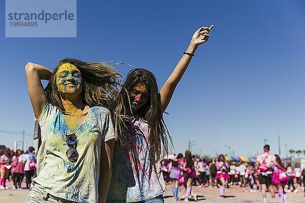 Zwei glückliche junge Frauen genießen das Tanzen beim Holifest