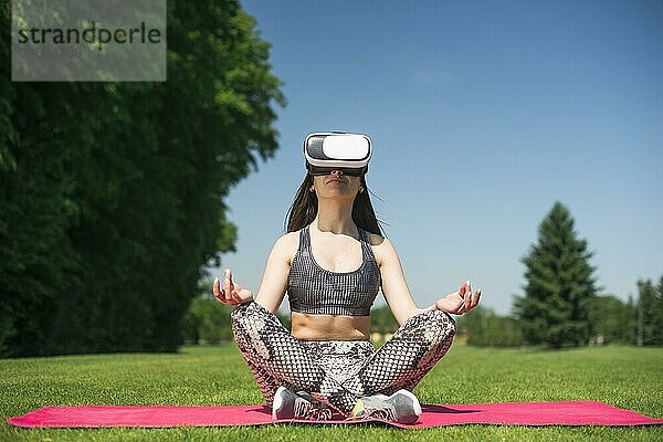 Sportliche Frau mit Virtual Reality Brille im Freien