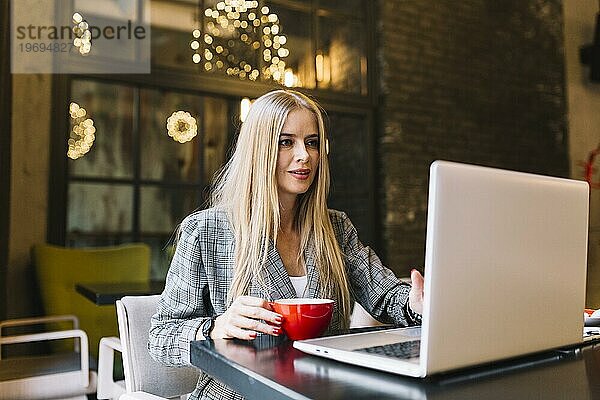 Stilvolle Geschäftsfrau mit Laptop gemütliches Café