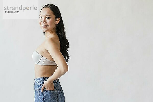 selbstbewusste asiatische Frau posiert BH Jeans