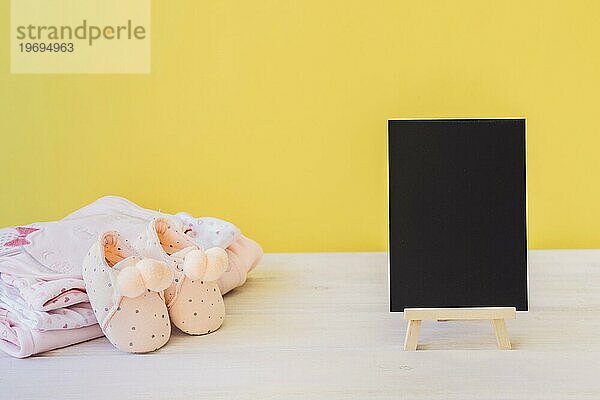 Neugeborenes Konzept mit Board Babykleidung