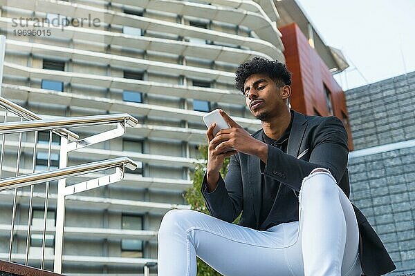 Niedrige Winkelansicht Foto mit Kopie Raum eines entspannten arabischen jungen Geschäftsmann mit Telefon im Freien