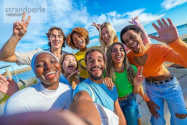 Glückliche multirassische Freunde machen ein Selfie und gestikulieren im Freien