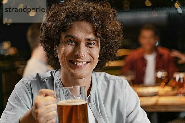 Close up smiley Mann hält Bierkrug Pub