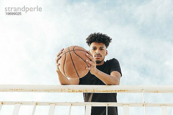 Basketballspieler mit Ball schaut in die Kamera