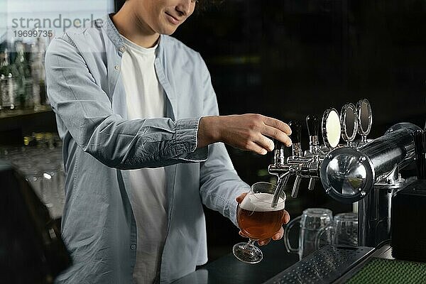 Nahaufnahme Mann gießt Bierglas