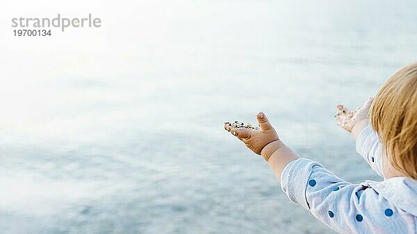 Seitenansicht Baby genießt Wasser Blick mit Sand Hände
