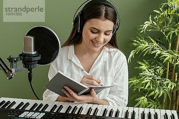 Frontansicht smiley weiblichen Musiker spielen Klavier Tastatur schreiben Songs während der Aufnahme