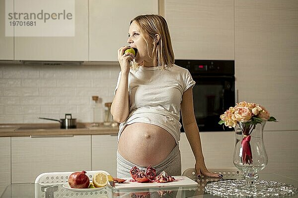 Vorderansicht schwangere Frau ißt Apfel