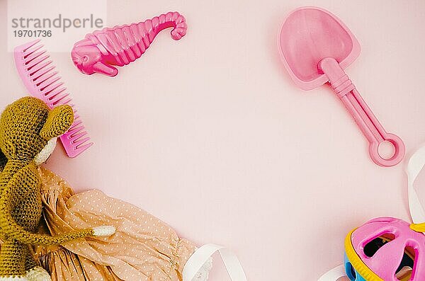 Flat lay Kinderspielzeug mit rosa Hintergrund