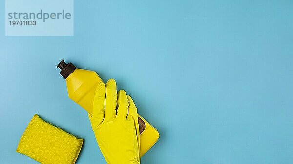Close up Hand mit gelben Handschuh blaün Hintergrund