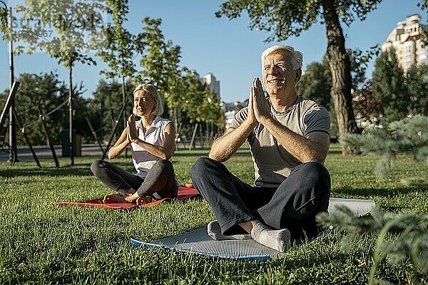 Älteres Paar praktiziert Yoga im Freien