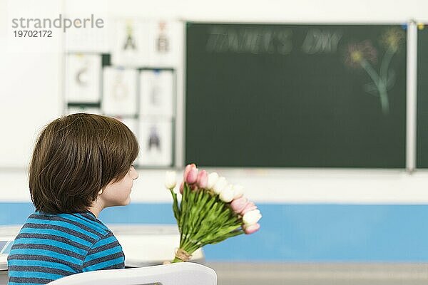 Kind hält Blumenstrauß Blumen sein Lehrer