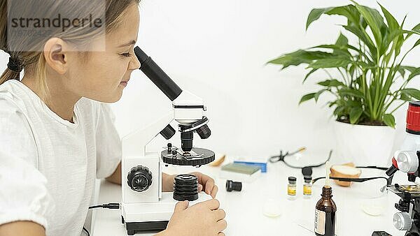 Mädchen schaut ins Mikroskop