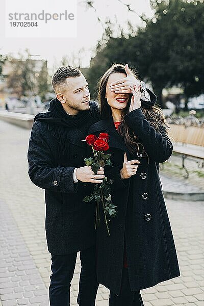 Mann mit Rosen überrascht junges Mädchen