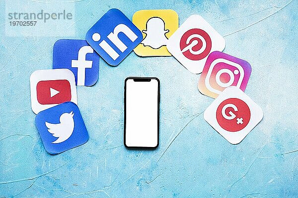 Blank Handy mit verschiedenen sozialen Netzwerken Papier Symbole blaün Hintergrund