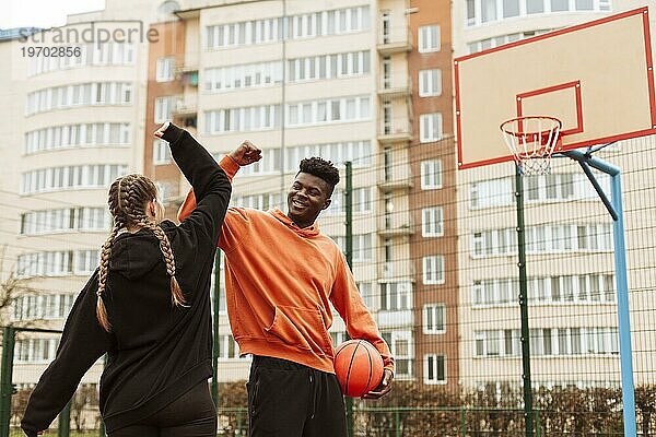Teenager spielen zusammen Basketball