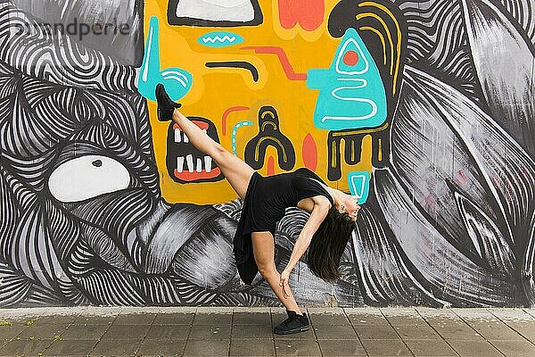 Tangotänzerin posiert vor kreativer Graffitiwand