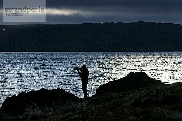 Silhouette  Fotograf mit Kamera und langer Brennweite  Steingrímsfjörður  Westfjorde  Island  Europa