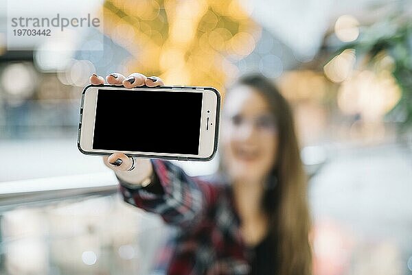 Frau hält Smartphone mit leerem Bildschirm