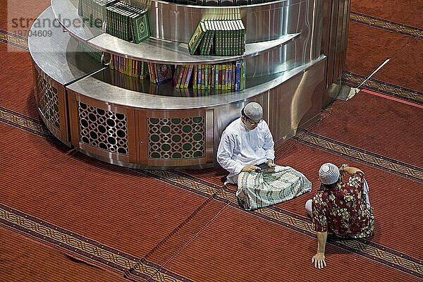 Ein Muslim überprüft sein Smartphone in der Istiqlal Moschee  Masjid Istiqlal  der größten Moschee Indonesiens und Südostasiens