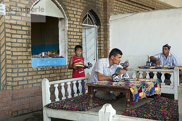Usbekische Männer trinken Tee und essen zu Mittag in Usbekistan