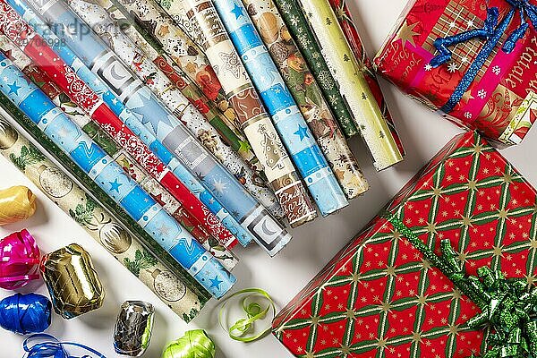 Mehrere Rollen Geschenkpapier  weihnachtlich  Geschenkbänder  Päckchen  weißer Hintergrund