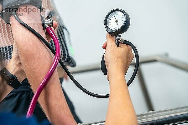 Hand eines Kardiologen mit einem Gerät zur Messung des Blutdrucks