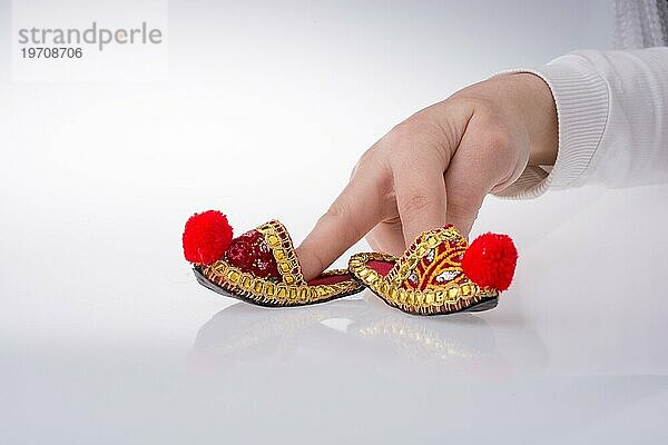 Hand hält traditionelle türkische handgefertigte Schuhe auf weißem Hintergrund