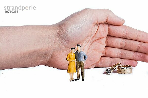 Schützende Hand kümmert sich um Paar in der Verlobungsphase mit Eheringen im Vordergrund