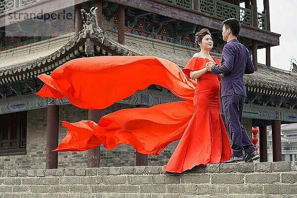 Hochzeitspaar steht auf der Stadtmauer In Xian  das Brautpaar hat dem Foto zugestimmt